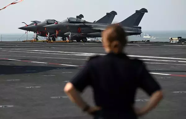 A French Navy sailor stands in front of Rafale fighter jets on the deck of the Charles de Gaulle aircraft carrier during the Indo-French Varuna joint naval exercise at Mormugao harbour in Goa state, India, on January 21. [Sajjad Hussain/AFP]