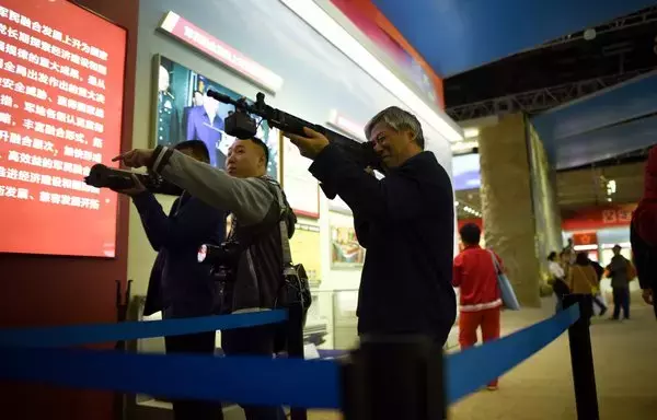 صورة التقطت في 10 تشرين الأول/أكتوبر 2017 تظهر زوارا يستخدمون جهاز محاكاة للأسلحة خلال معرض نظم في مركز معارض بيجين. [وانغ زاو/وكالة الصحافة الفرنسية]