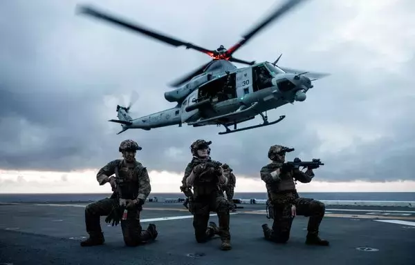 US Marines set security while conducting a fast-rope insertion from a UH-1Y Venom during a visit, board, search and seizure training aboard the amphibious assault ship USS Bataan in the Atlantic Ocean July 19. Fast-roping is a tactical maneuver used to quickly insert troops into austere terrain in which a helicopter may not be able to land. [US Marine Corps]