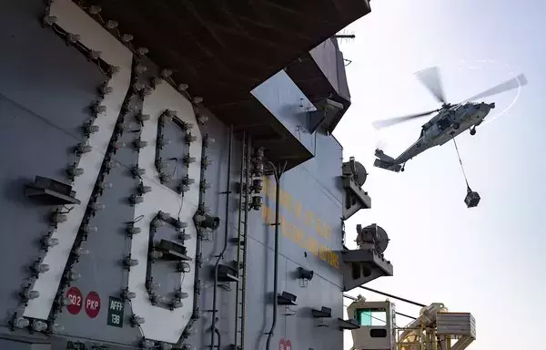 طائرة نايت هوك إم إتش-60 إس، تقوم بنقل البضائع من يو إس إن إس ميدغر إيفر إلى مدرج الطيران لأكبر حاملة طائرات في العالم، "يو إس إس جيرالد فورد من طراز (سي في إن 78)، خلال عملية تجديد الموارد عند تطور البحر في 21 يوليو/تموز. [مشاة البحرية الأميركية]