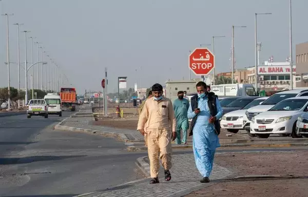 Foreign nationals walk on the outskirts of the capital of the United Arab Emirates, Abu Dhabi, after a suspected drone attack blew up petrol tanks near a major oil storage facility in the area on January 17, 2022. [AFP]