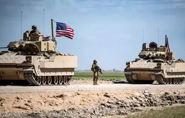 US Bradley fighting vehicles patrol the countryside of the Syrian city of Qamishli in the northeastern province of al-Hasakeh on April 20, 2022. [Delil Souleiman/AFP]