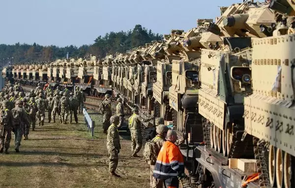 US Army personnel unload heavy combat equipment including Abrams tanks and Bradley fighting vehicles at a railway station near the Pabrade military base in Lithuania on October 21, 2019. [Petras Malukas/AFP]