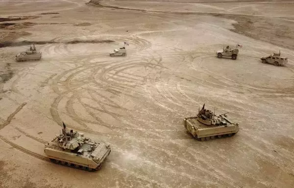 A photo taken December 7, 2021, shows an aerial view of US Bradley fighting vehicles during a joint military exercise between the Syrian Democratic Forces and the US-led international coalition against ISIS, in the countryside of Deir Ezzor province, Syria. [Delil Souleiman/AFP]