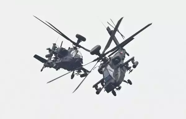 Two US-made Apache attack helicopters, from Taiwan's Army Airborne Special Forces, demonstrate their combat skills during a military open house event in Hsinchu, Taiwan, on September 21. [Sam Yeh/AFP]