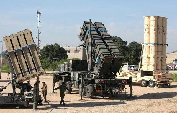 جنود إسرائيليون يسيرون بالقرب من منظومة دفاع القبة الحديدية الإسرائيلي (إلى اليسار) ومنظومة صواريخ أرض جو (سام) ومنظومة إم آي إم-104 باتريوت (إلى الوسط) وصاروخ آرو 3 المضاد للصواريخ البالستية (إلى اليمين)، وذلك خلال إحاطة صحفية لمناورة مشتركة في قاعدة حتسور الجوية الإسرائيلية في وسط إسرائيل،عام 2016. [جيل كوهين ماجن/وكالة الصحافة الفرنسية]