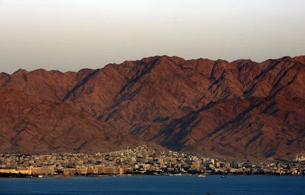 A general view shows the Red Sea Jordanian city of Aqaba at sunset on September 24, 2018. [Thomas Coex/AFP]