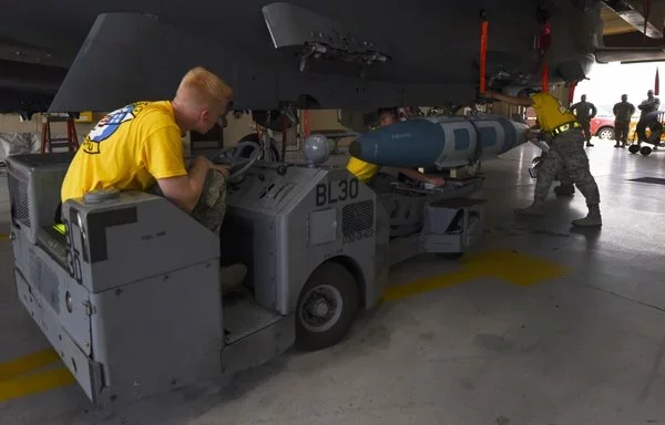 طاقم صيانة الطائرات يحمّل ذخيرة الهجوم المباشر المشترك جي بي يو-31 على متن طائرة، في 13 تموز/يوليو 2018، في ولاية كارولينا الشمالية. [سلاح الجو الأميركي]