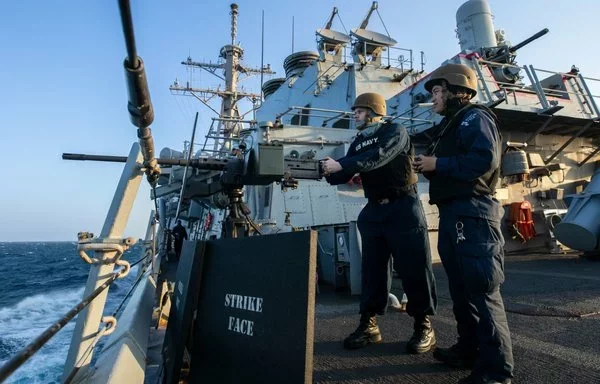 US sailors man a .50-caliber machine gun as the guided-missile destroyer USS Laboon prepares to transit the Bab al-Mandeb Strait in the Red Sea January 9. [US Navy]