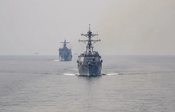 The USS Michael Murphy, near, and the amphibious landing dock USS Pearl Harbor, far, transit the Strait of Malacca on January 11, 2022. [US Navy]