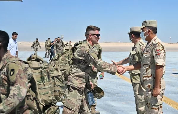 Soldiers from the Texas National Guard and Minnesota Army National Guard shake hands with Egyptian military officers after arriving at Borg El Arab International airport September 1, 2021. [US Army]