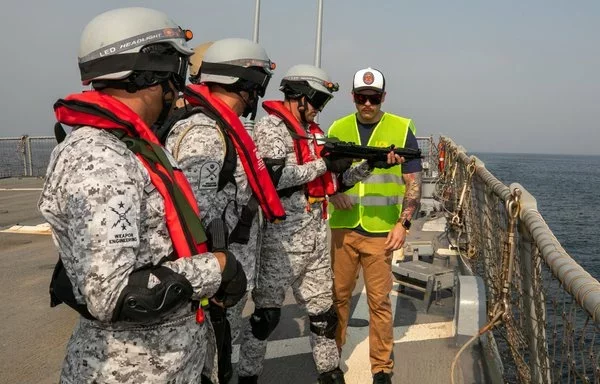 A US sailor (yellow vest) checks clear and safe procedures of Pakistani sailors during a visit, board, search and seizure exercise aboard the Arleigh Burke-class guided-missile destroyer USS O'Kane. [US Navy]